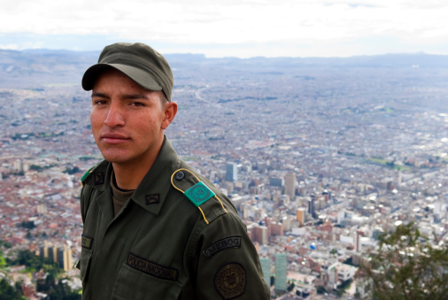 Bogota, Colombia - May 28, 2009: A Colombian police officer stands at Monserrate, a mountain dominating the city center of Bogota, the city below him.