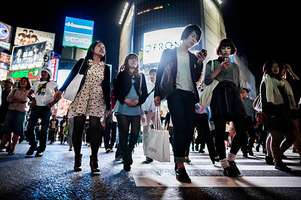 Shibuya Crossing Tokyo Japan Tokyo, Japan - October 13, 2012: People in Shibuya Crossing at night Tokyo Japan. With 15 square kilometer and a resident population of more than 200000 people it has become one of the best shopping districts of the city specially for young people. It has also a lively nightlife and the streets are busy until late at night. Shibuya is also worldly know by the scrambling crossing in from of the train station and it categorized as the busiest street crossing in the world. This area is always brightly lit by neon signs and big advertising flat screens low angle street japan stock pictures, royalty-free photos & images