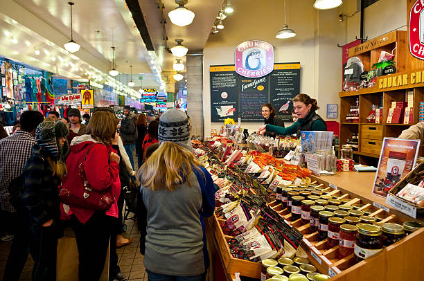 Pike Place Market in Seattle Seattle, Washington, USA - March 23, 2012: Employees and customers interact over products at Chukar Cherries inside Pike Place Market. One of many shops inside the market, Chukar Cherries specializes in dried cherries, blueberries, strawberries, and more. pike place market stock pictures, royalty-free photos & images