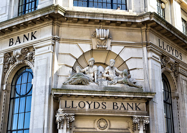 Lloyds Bank signs, King's Lynn "Kings Lynn, England - September 17, 2012: Carved stone signs on the front of a branch of Lloyds Bank in Kings Lynn, Norfolk, England. The carvings are covered with netting intended to prevent pigeons and other birds from roosting there and causing a nuisance. Lloyds Bank dates back to 1765 and has seen many changes and acquisitions since then, including a merger with TSB (Trustee Savings Bank) in 1995 and the acquisition of HBOS (Halifax Bank of Scotland) in 2009. The company is now named Lloyds Banking Group." kings lynn stock pictures, royalty-free photos & images