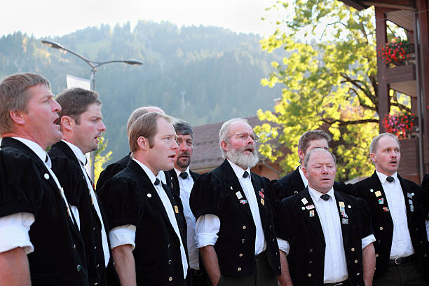 Swiss male yodel choir show facial expressions at agricultural festival Lenk im Simmental, Switzerland - October 13, 2012: At the culmination of the annual Aelplerfest agricultural show celebrations, a Swiss male voice choir entertains locals and visitors in the town square. The choir is dressed in traditional Swiss costume and specialise in local tunes with the emphasis on high counter-tenor, yodelling harmonies, and show a range of facial expressions. choir photos stock pictures, royalty-free photos & images