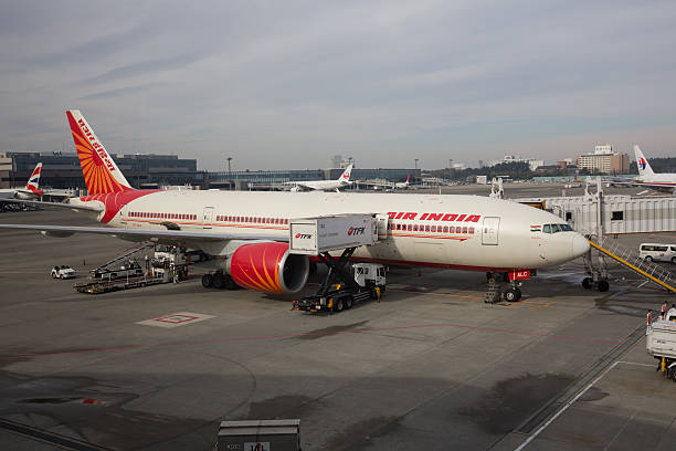 Air India Boeing 777-200 in Japan "Narita, Japan - November 29, 2012 : Air India Boeing 777-200 parked at Narita International Airport, Chiba, Japan. It is the flag carrier airline of India. Some workers are working at the airport." narita japan stock pictures, royalty-free photos & images