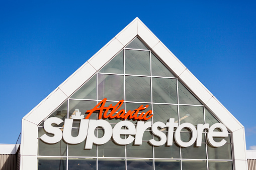 Halifax, Nova Scotia, Canada - March 29, 2012: Atlantic Superstore logo above entrance to supermarket.  Clear glass behind logo where a kitchen resides and cooking classes take place.  Blue, clear sky fills the remainder of the frame.  The Atlantic Superstore is Atlantic Canada's supermarket chain of over 50 stores (as of March, 2012) in the Maritime provinces of Nova Scotia, New Brunswick, and Prince Edward Island.  It is a division of Loblaws.
