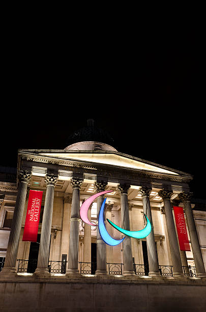 Paralympics symbol at the National Portrait Gallery, Trafalgar Square, London "London, United Kingdom - August 26, 2012: Paralympics logo installed outside the imposing entrance to National Portrait Gallery in Trafalgar Square, night shot. The giant Paralympic Agitos symbol comprises three asymmetric crescents in red, green and blue, symbolising motion. copyspace" agitos photos stock pictures, royalty-free photos & images