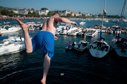 Syracuse, Sicily, Italy August 14, 2019 A middle-aged man dives into the Mediterranean from a rock