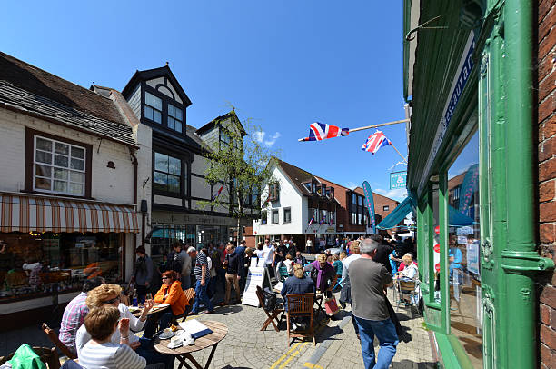 Christchurch High Street "Christchurch , UK - May 12, 2012: The pedestrianised area of Christchurch town centre in Dorset. People sitting outside cafes and others walking around." christchurch england photos stock pictures, royalty-free photos & images
