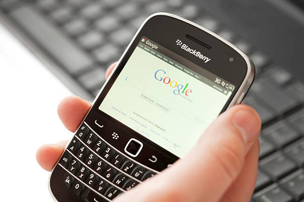 pda smartphone dans la main mâle - google searching internet e commerce photos et images de collection