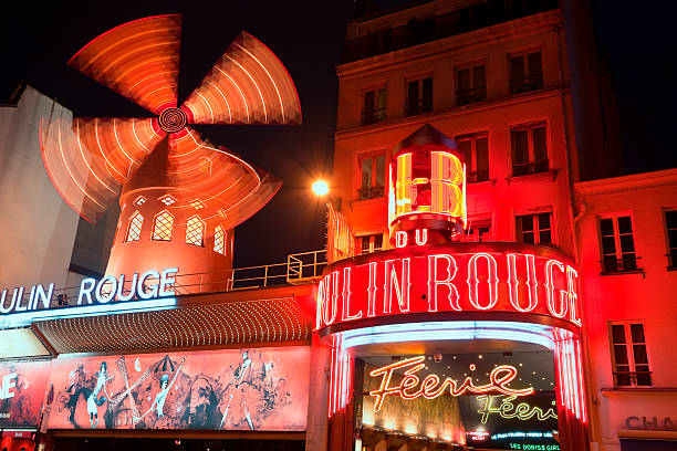The Moulin Rouge Cabaret at Night, Paris, France "Paris, France - April 28, 2012: Le Moulin Rouge cabaret at saturday evening. Le Moulin Rouge is one of the most famous places in Paris, built in 1889 and located close to Montmartre in the red-light district Pigalle in the 18th arrondissement of Paris." place pigalle stock pictures, royalty-free photos & images