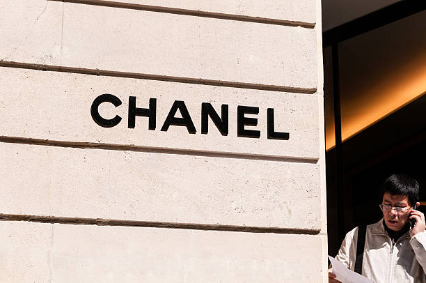 Paris, France - May 14, 2012: an asian man is standing at the door of Chanel shop in rue Montaigne. Rich asian people are nowadays among the best customers of upscale, high fashion stores in Europe.