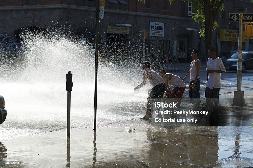 Fire Hydrant New York City Summer Day "New York City, USA - July 16, 2006: Group of young men gather to splash in open fire hydrant in upper Manhattan. The fact that tampering with fire hydrants is illegal doesn't stop people from opening them on hot summer days." Fire Hydrant Stock Photo