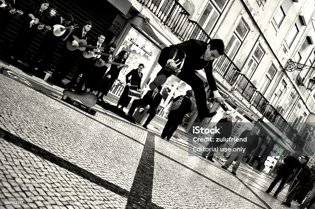 Student Dancing in Lisbon "Lisbon, Portugal - December 8, 2012: A student dances in the Rua Augusta in Lisbon downton, while other students from the same group, sing and play music." Adult Stock Photo