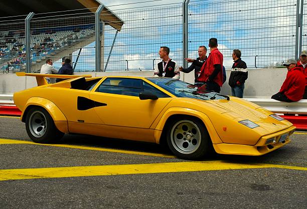 Zandvoort, The Netherlands - June 20, 2004: Yellow Lamborghini Countach driving in the pit lane of the Zandvoort race track during the 2004 Italia a Zandvoort days. People in the background are looking at the cars.