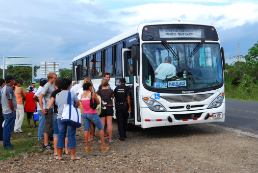 Liberia, Costa Rica - November 21, 2008: A bus traveling from the Nicaraguan border to the Costa Rican city of Liberia is stopped by police on the side of the road. Passengers wait outside while the bus is searched for illegal immigrants from Nicaragua.
