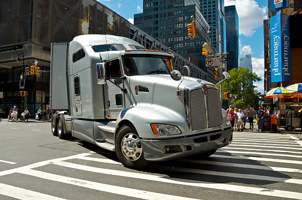 18-Wheeler Tractor-Trailer truck turning onto 8th Ave, Manhattan, NYC "New York City, USA - September 10, 2012: A Tractor-Trailer 18-Wheeler truck is seen as it makes a sharp turn from W.42nd Street onto 8th Avenue while pedestrians wait for it to pass as it heads northbound in West Midtown Manhattan." 42nd street photos stock pictures, royalty-free photos & images