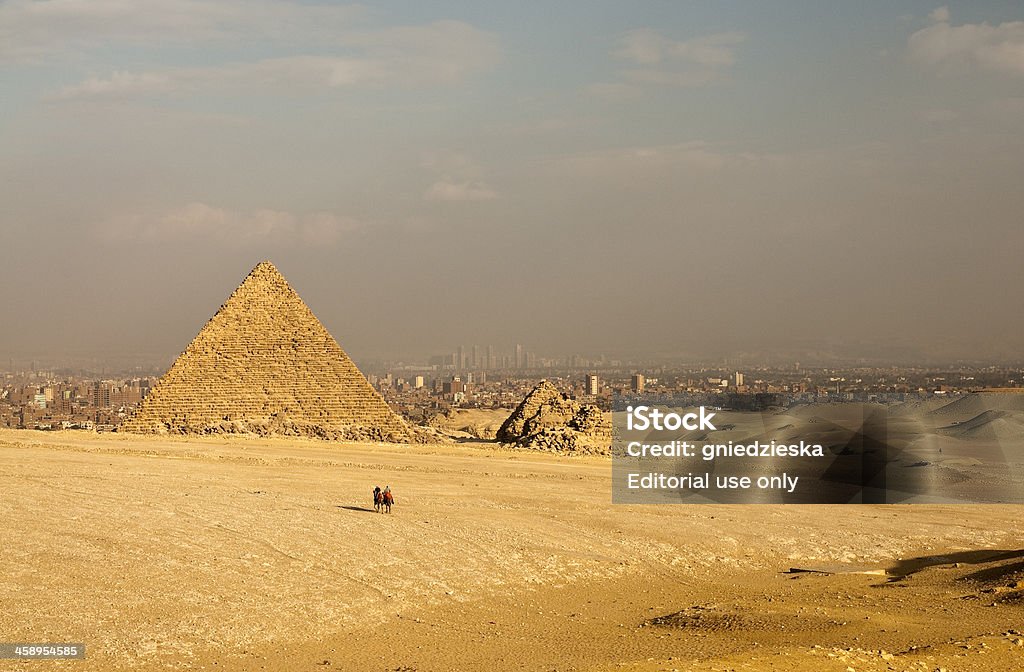 Mykerinos piramide in Giza "Cairo, Egypt - November 19th, 2011: This is the pyramid of Mykerinos in Giza nearby Cairo in Egypt. Two Egyptians are crossing the desert on the camels. This photo was taken from the special viewing area (designed for tourists) at late afternoon." Autumn Stock Photo