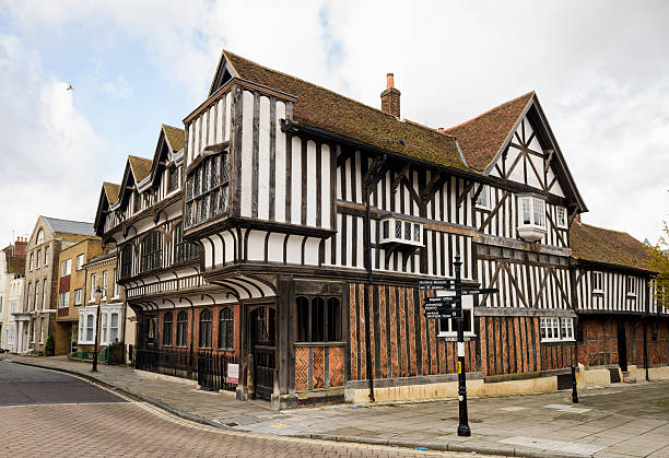 Tenison Road, Cambridge, England - November 9th 2023:  Young woman walking in front of a English yellow brick townhouse with traditional chimneys