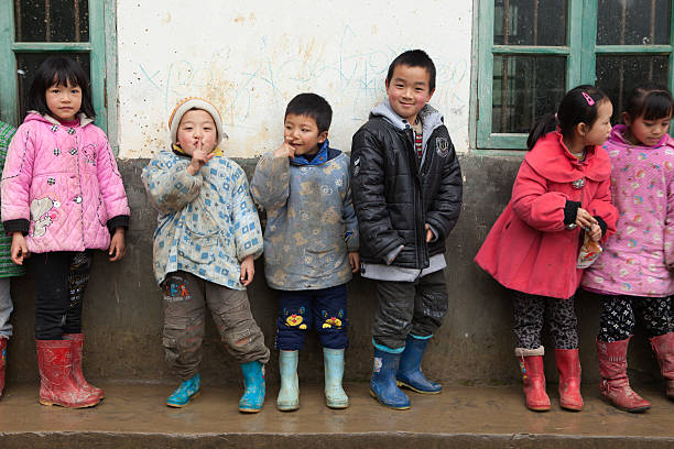 Yang Mei Ling, Guilin, China - March 15, 2012: Poor elementary students of Yang Mei Ling Primary School. Yang Mei Ling is a small village. Image has been captured in front of their decrepit school.