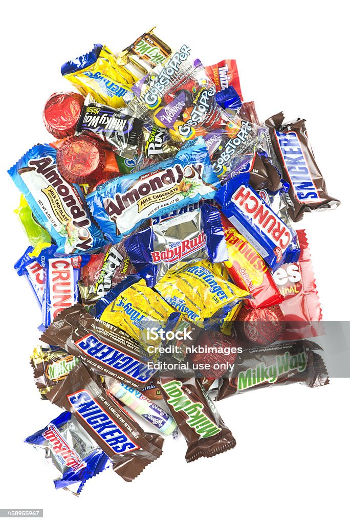 Pile of candy on white background "Cincinnati, Ohio - October 2, 2012: Pile of candy on white background.  Candy includes Snickers, Nestle Crunch, Almond Joy, Milky Way, Three Musketeers, Butterfingers, Reeses, Skittles, Gobstoppers and Starburst." Candy Stock Photo