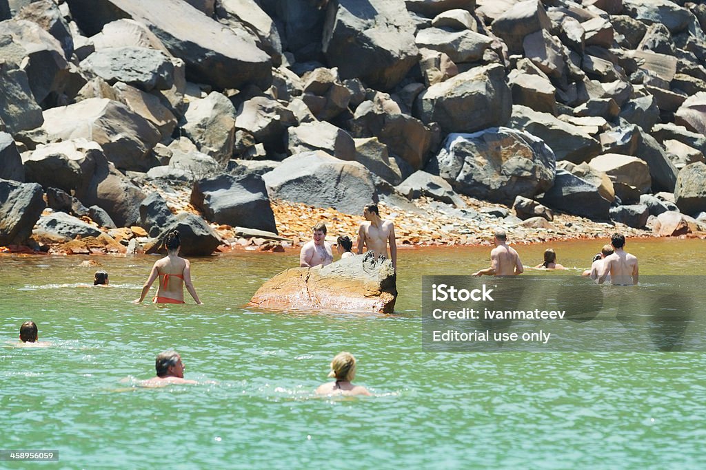Palaia Kameni, Santorini "Fira, Greece - May 04, 2012 : Tourists bathing in the waters of Palaia Kameni, a small unhabited volcanic island" Aegean Islands Stock Photo