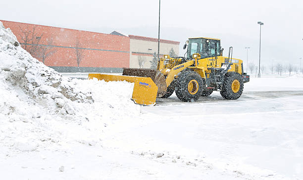 Clean up. "Plainville, Connecticut, USA-February 8, 2013: private contractor using heavy machinery to remove snow from community parking lots during blizzard conditions." snow plow stock pictures, royalty-free photos & images