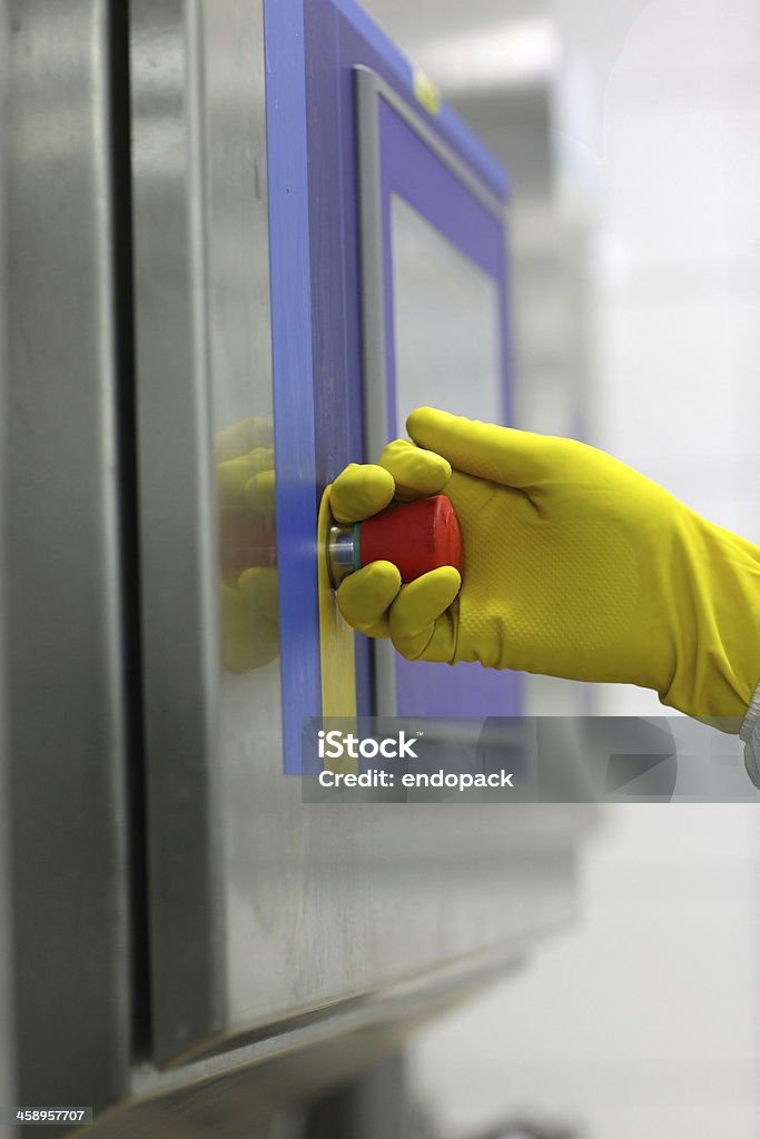 La main dans le gant toucher technologie bouton sur le panneau de contrôle - Photo de Accident et désastre libre de droits