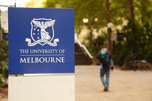 Melbourne, Australia - April 9, 2012: The University of Melbourne is the premier tertiary education facility in Melbourne Australia. Here a student walks past an entry sign.