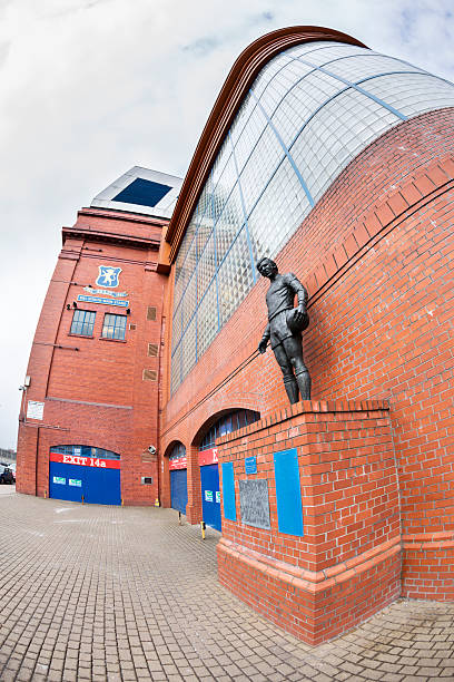 Ibrox Stadium Disaster Memorial, Glasgow "Glasgow, UK - March 26, 2013: A statue of John Greig outside Ibrox Stadium, Glasgow, the home ground of Rangers Football Club. The statue commemorates those killed in the first Ibrox Disaster when a stand collapsed in 1902, in a crush on a stairway in 1961, and in the second Ibrox Disaster in 1971 when 66 died in a crush when leaving the ground. John Greig was the Rangers captain at the time of the 1971 disaster. The memorial was created by sculptor Andy Scott and unveiled on 2 January 2001." ibrox stock pictures, royalty-free photos & images