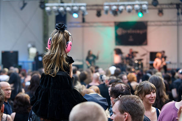 Bambina con protezione per le orecchie in concerto - foto stock