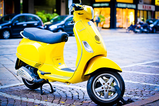 amarelo scooter vespa vintage estacionados na rua de milão - vespa scooter imagens e fotografias de stock