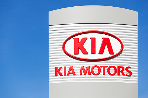 Halifax, Nova Scotia, Canada - March 25, 2012: Kia Motoros logo above dealership lot on a clear sunny day.  Clear blue sky behind sign.  Kia Motors is South Korea's second-largest automobile manufacturer and features models such as the Rio, Forte, and Soul.