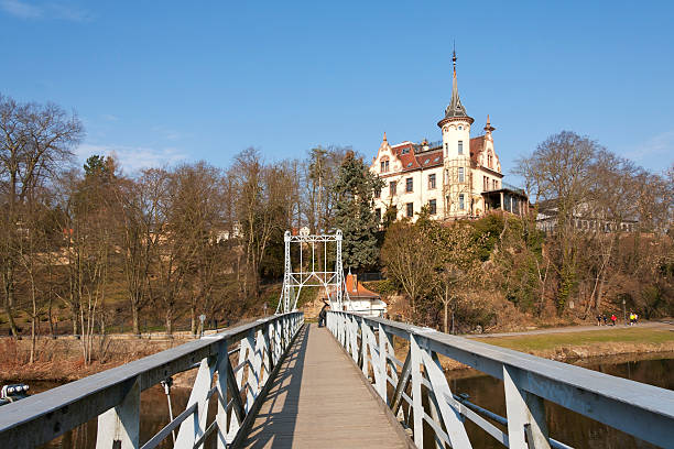 Chain bridge, Grimma "Grimma, Germany - March 18, 2012: View to a beautiful villa, standing on the hill in Grimma, Germany. The bridge in foreground is an historival chain bridge only for people. The bridge was built 1924 and traversed the River Mulde." grimma stock pictures, royalty-free photos & images