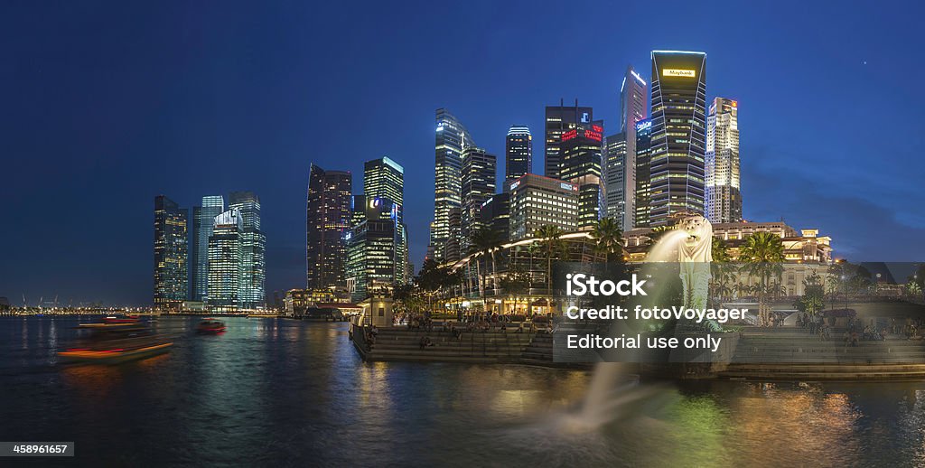 Singapore Merlion Fountain Marina Bay skyscapers neon night "Singapore, Singapore - 14th February 2012: The crowded cityscape of Central Business District skyscrapers overlooking the Merlion fountain on the Marina Bay waterfront at dusk as tourists and locals enjoy the warm evening promenade. Composite panoramic image created from six contemporaneous sequential photographs." Merlion - Fictional Character Stock Photo