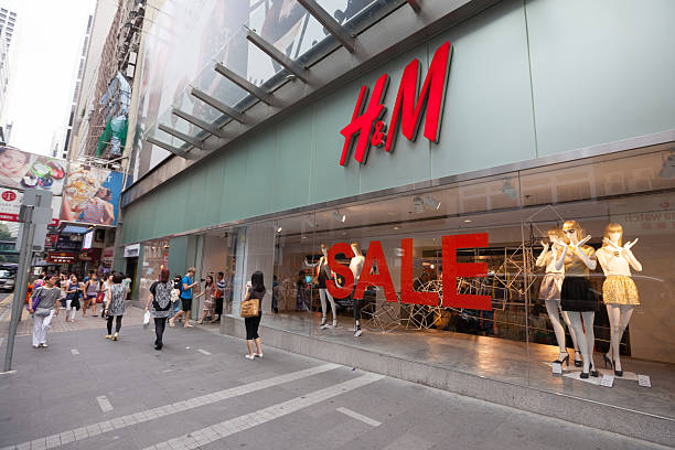 H&M fashion store in Hong Kong "Hong Kong, China - July 20, 2012: Pedestrians walk past the H&M fashion store. This store is located in 68 Queens Road, Central, Hong Kong. H&M is Europe's second-largest clothing retailer. Some shoppers are inside the shop." h and m stock pictures, royalty-free photos & images