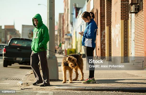 Hombre Con Perro Y Chica Joven Esperando Luz Verde Foto de stock y más banco de imágenes de Adolescente - Adolescente, Adulto, Adulto joven