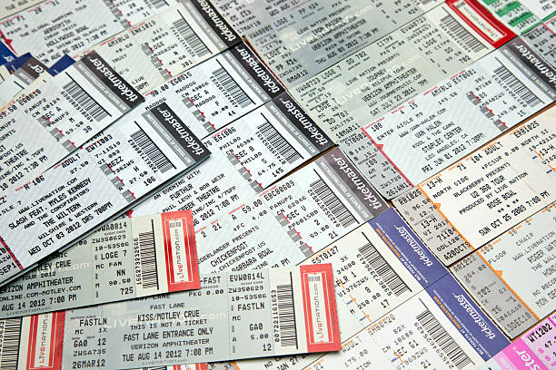 A man displays a sign advertising tickets for sale, a common practice among ticket scalpers