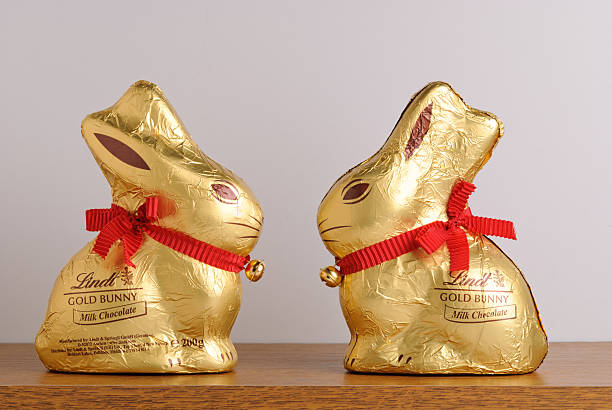 Two Lindt Gold Bunnies Facing on Shelf stock photo