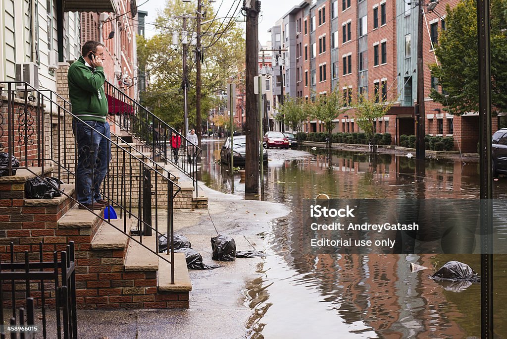 Hurrican Sandy: Mężczyzna rozmawia przez telefon w pobliżu zalane street - Zbiór zdjęć royalty-free (Powódź)