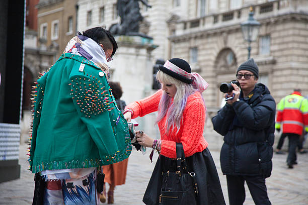 London Fashion Week "London, United Kingdom - February 18, 2012: Fashion students and photographer outside Somerset House during London Fashion Week. One of the students is adjusting the other's clothing. London Fashion Week 2012 was held at various venues in the city but was centred at Somerset House." london fashion week stock pictures, royalty-free photos & images