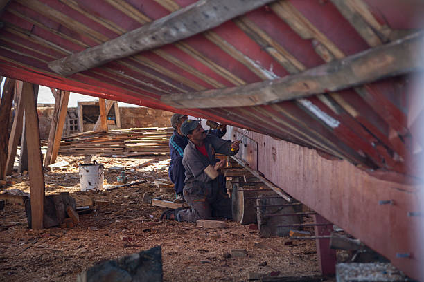 la construcción naval: dos hombres usando cinceles en barco hull - work tool chisel wood mallet fotografías e imágenes de stock