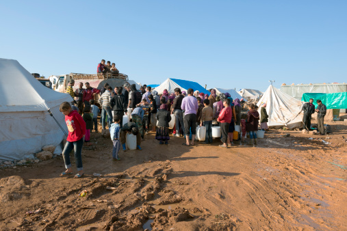 Atmeh, Syria - January 14, 2013: Refugees wait to retrieve water from a water truck at the camp for displaced persons in Atmeh, Syria