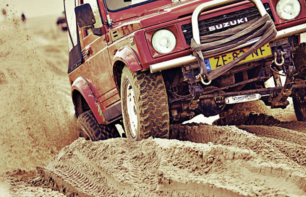 Rockanje, The Netherlands - September, 30 2012:  off-road Suzuki vehicle accelerating in sand during non-professional competition