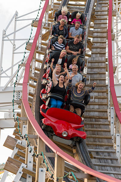 Riders scream on a ride at Stockholm's Grona Lund "Stockholm, Sweden - August 17, 2012: Riders scream as the rollercoaster called Twister swooshes past.This ride reaches a speed of 61 km/h and the riders are suscepted to forces up to 3G.The highest point is 15 m above the sea level.The Grona Lund amusement park is situated near the city center of Stockholm." djurgarden photos stock pictures, royalty-free photos & images