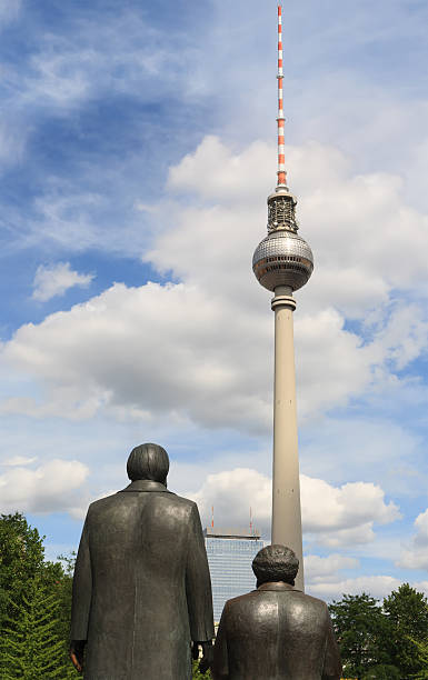 Marx-Engels-Forum and Fernsehturm (TV tower) at the Alexanderplatz "Berlin, Germany - July 30, 2009: The Fernsehturm, a television tower in Berlin, seen from the Marx-Engels-Forum. Marx-Engels-Forum is a public park in the central Mitte district of the city. The Fernsehturm at the Alexanderplatz is the tallest structure in Germany and it is one of the landmarks of the German capital." friedrich engels stock pictures, royalty-free photos & images