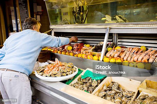 Uomo Ridisposizione Frutti Di Mare Presso Il Ristorante Ingresso Visualizzato - Fotografie stock e altre immagini di Adulto