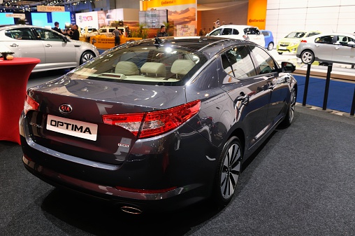 Brussels, Belgium - January 10, 2012: Silver Kia Optima sedan on display during the 2012 Brussels motor show. People in the background are looking at the cars.