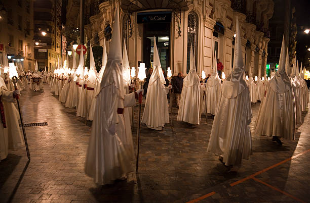 Procession of Nazarenos during Semana Santa in Cartagena, Spain "Cartagena, Spain - March 30, 2013: Nazarenos parading during Semana Santa. Easter week is celebrated in Spain with processions of hooded Nazarenos, accompanied by military bands and huge floats (called Tronos) with representations of scenes from the last week of Christ's life." cartagena spain stock pictures, royalty-free photos & images