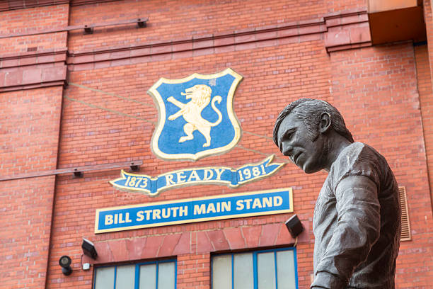Ibrox Stadium Disaster Memorial, Glasgow "Glasgow, UK - July 21, 2012: A statue of John Greig outside Ibrox Stadium, Glasgow, the home ground of Rangers Football Club. The statue commemorates those killed in the first Ibrox Disaster when a stand collapsed in 1902, in a crush on a stairway in 1961, and in the second Ibrox Disaster in 1971 when 66 died in a crush when leaving the ground. John Greig was the Rangers captain at the time of the 1971 disaster. The memorial was created by sculptor Andy Scott and unveiled on 2 January 2001." ibrox stock pictures, royalty-free photos & images