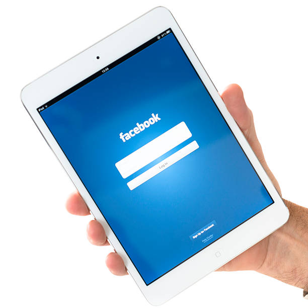 ludzką ręką trzymając nowy ipad mini z facebook.com aplikacji - ipad iphone isolated ipad mini zdjęcia i obrazy z banku zdjęć