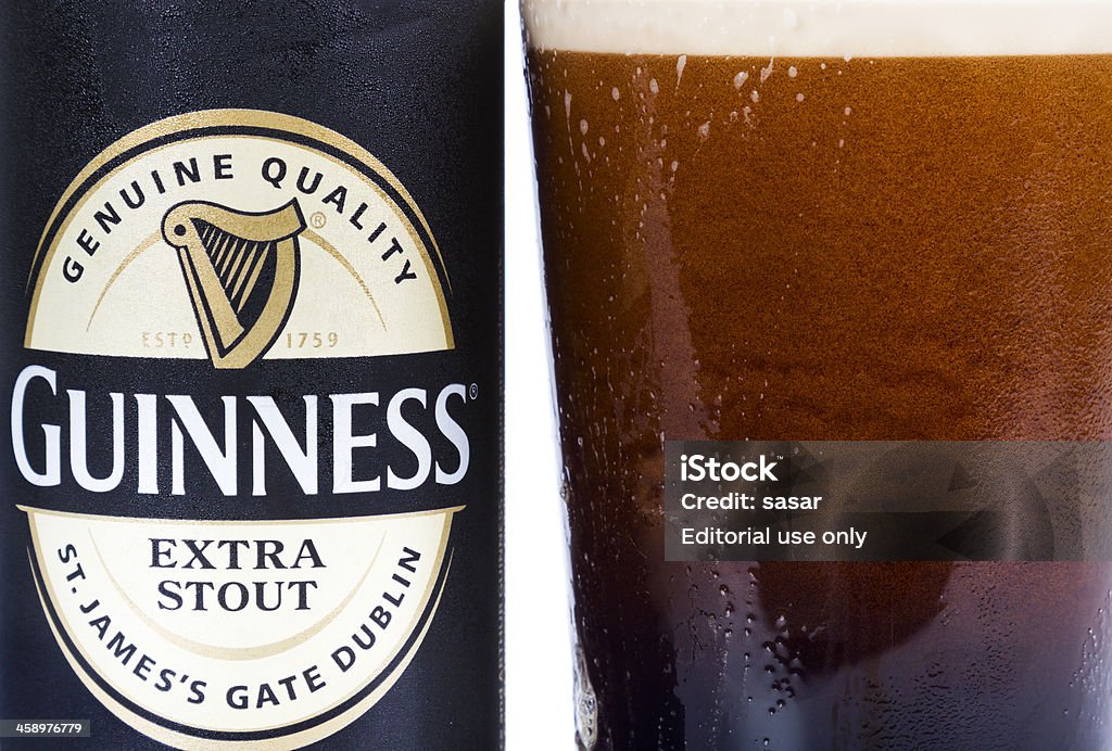 Guinness Extra Stout "Dublin, Ireland - September 12, 2012. This is a studio product shot of a can of Guinness stout next to a glass of freshly poured glass of the same product." Guinness Stock Photo