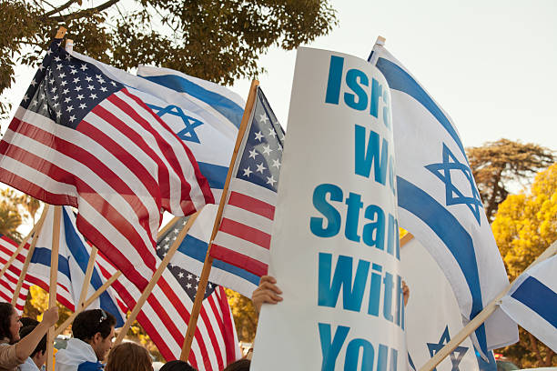 A blue Jewish star or Magen David at the center of an Israeli flag hanging at an angle from the side of a building.